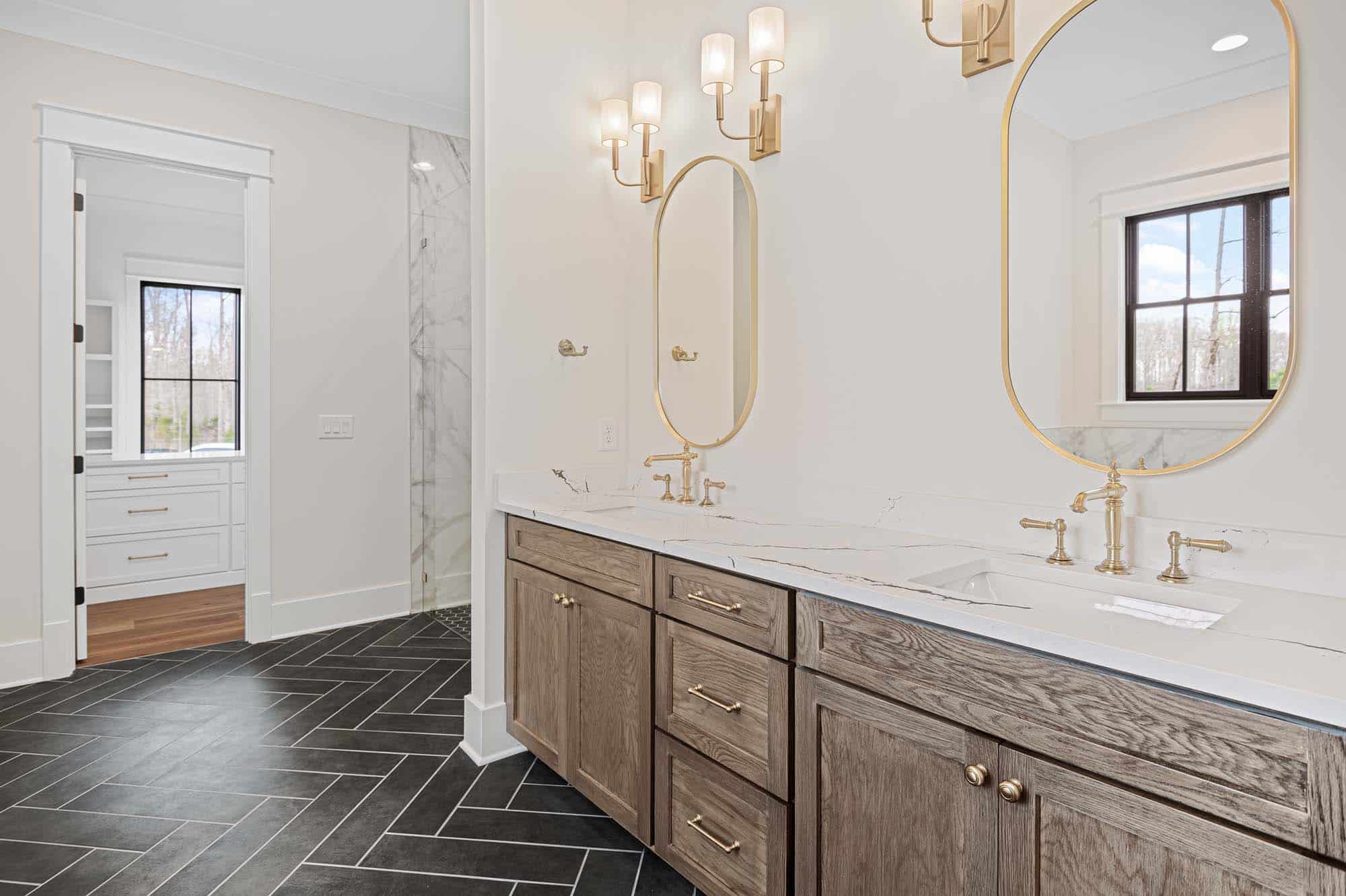 Blackberry Ridge bathroom with white sinks and black tile floor